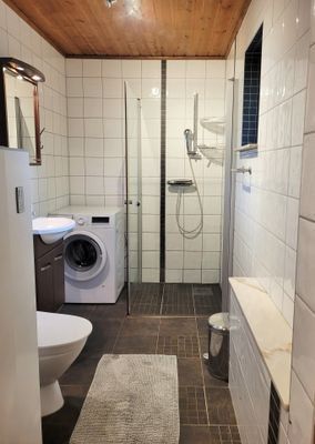 Badrum med dusch och tvättmaskin