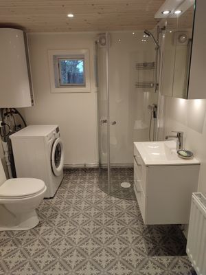 Badrum med dusch och tvättmaskin