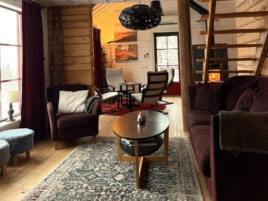 Vardagsrum på nedervåningen. Soffa, två fåtöljer, sittpuff. TV med Chromecast