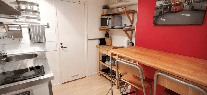 Litet kök med barbord och tre stolar