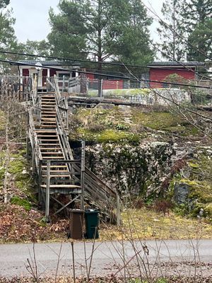 Brant trappa upp till huset ifrån parkering (för en bil) nere vid vägen. Flera parkeringsplatser finns på baksidan av huset.