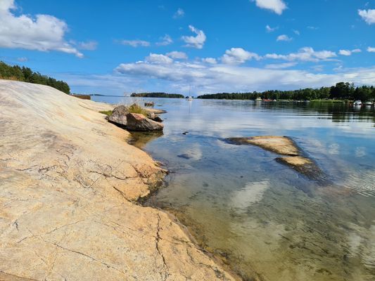 Stuga vid havet, nära strand och skog.