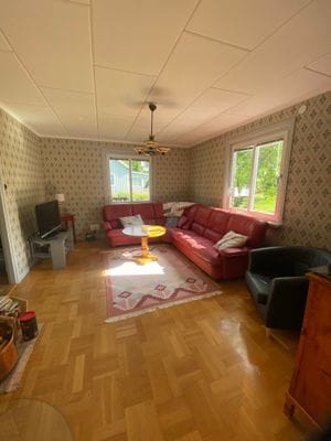 Vardagsrum med rymlig soffa, TV och fåtölj