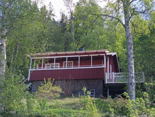 Liten stuga mellan sjö och skog