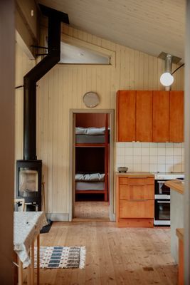 Bakom braskaminen i gästhuset skymtar ett av rummen.