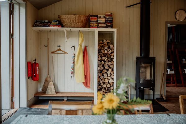 Gästhusets braskamin och öppna hall. Det finns spel på en hylla och även böcker att byta med.