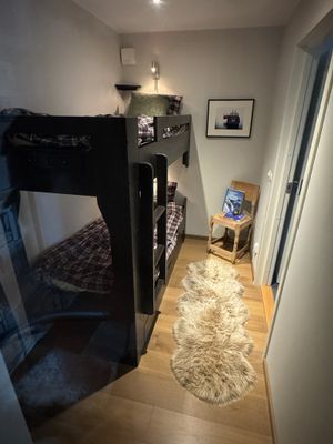 Tredje sovrummet, platsbyggd massiv våningssäng i furu med generös sänglåda 170 cm under och plats för väskor och kläder på kroklister i rummet