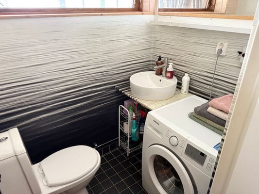 Till vänster om hallen som leder till vardagsrummet på bottenvåningen har ni ett fullt utrustat badrum/toalett med tvättmaskin