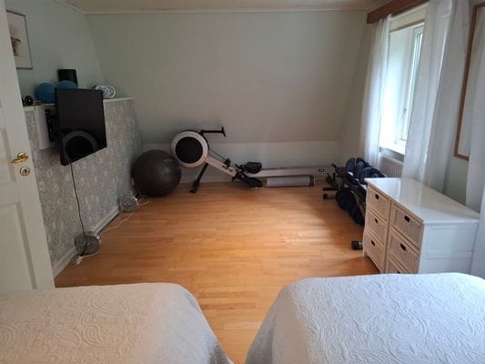 ...ett litet gym med roddmaskin, hantlar och yogamatta